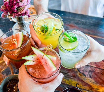 Groupe d'amis qui trinquent avec des cocktails fruités