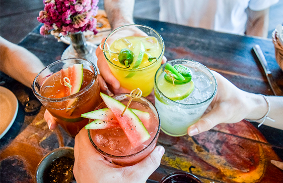 Groupe d'amis qui trinquent avec des cocktails fruités